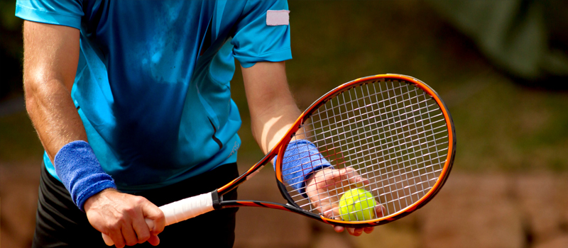 Jogador de tênis com raquete e bola nas mãos
